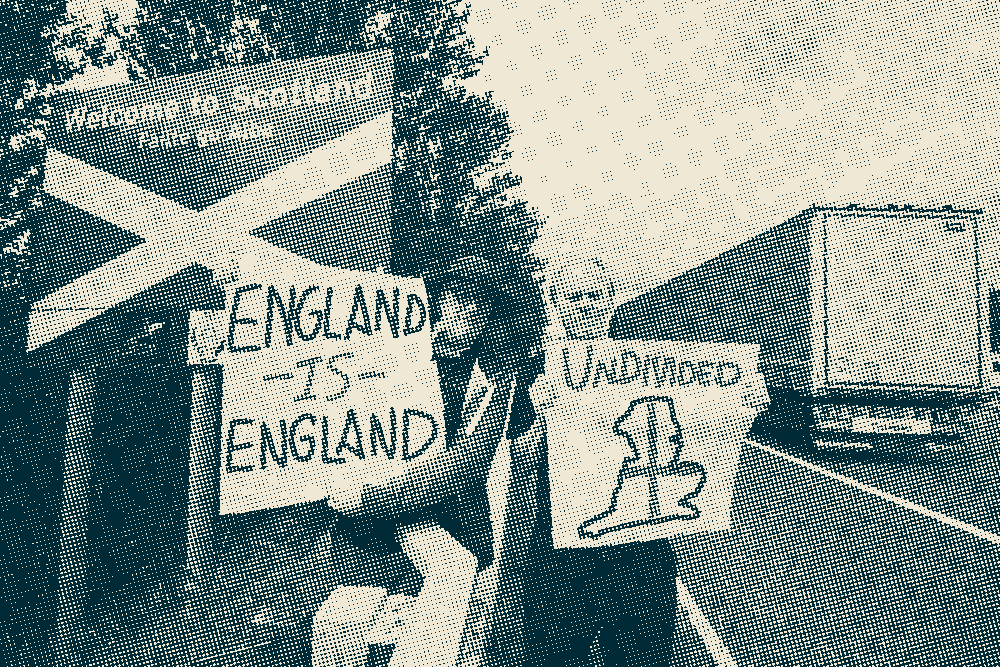 Two men at the Scottish border. They are holding placards reading 'England is England' and 'Undivided'.